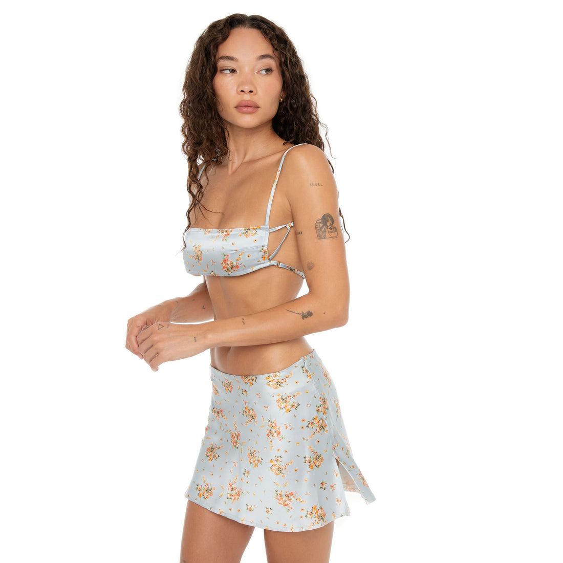 Model in Itsi Floral Skirt Sky, floral silk mini with playful side slits. **sky