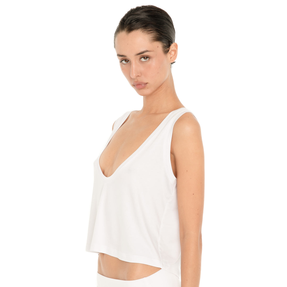 Three-quarter close-up of the white Kasia Top, highlighting the deep scoop neckline, wide shoulder straps and softly draped fit. **white