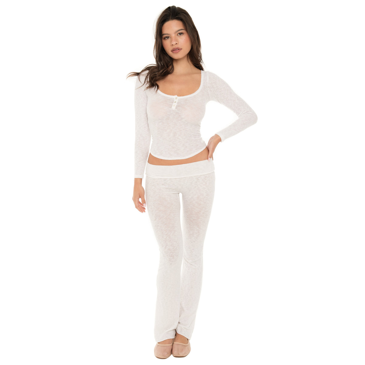 Model standing facing forward wearing a sheer white long sleeve scoop neck henley top with three buttons, paired with matching white lounge pants. **white