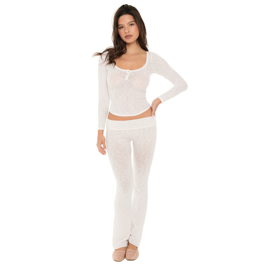Model standing facing forward wearing a sheer white long sleeve scoop neck henley top with three buttons, paired with matching white lounge pants. **white
