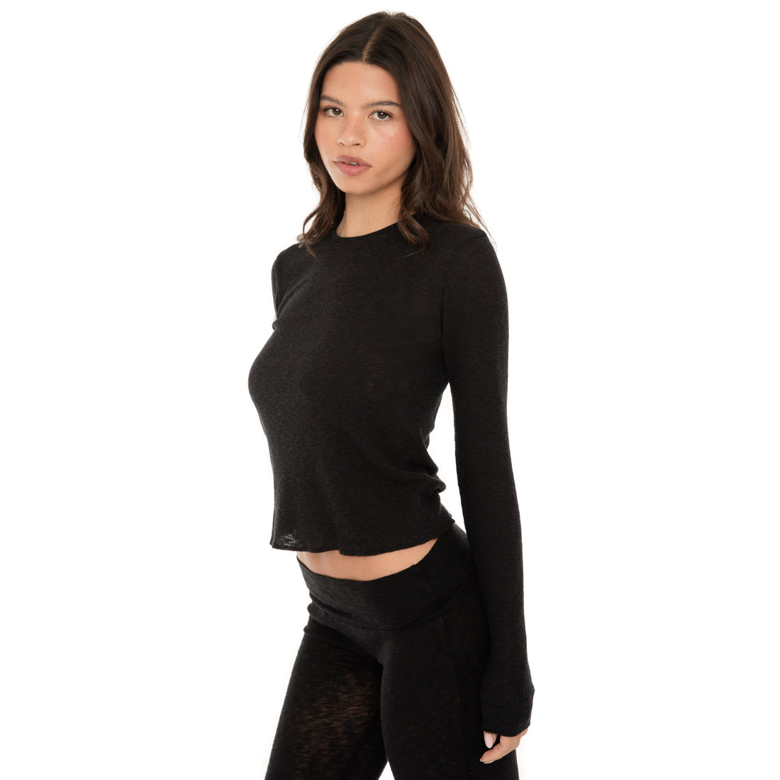 detail view of Caeli thermal top showing thick cuffs and exposed overlock hem **black