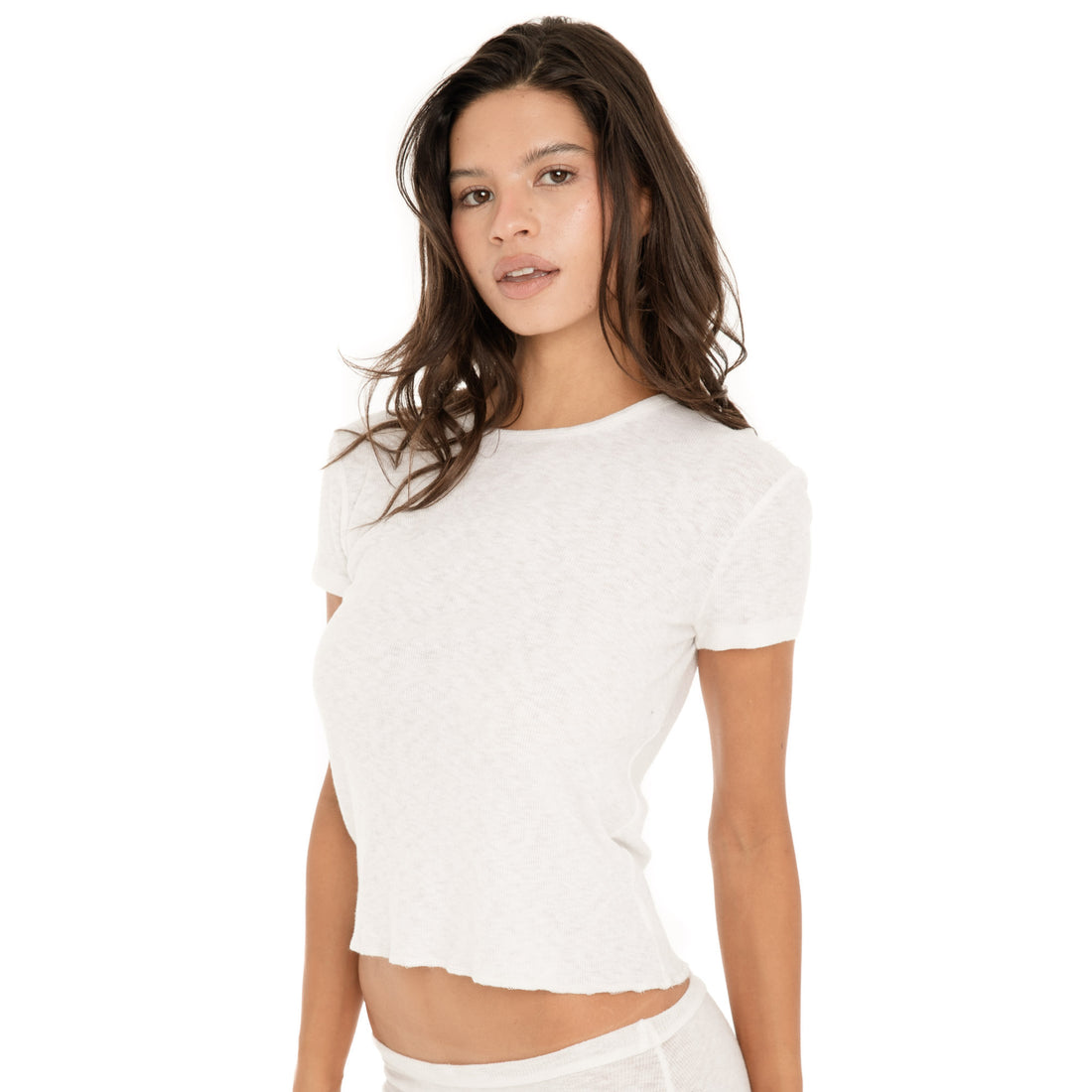 Three-quarter front view of the Kimi Tee in White, highlighting its relaxed silhouette, short sleeves, and cropped hem**white