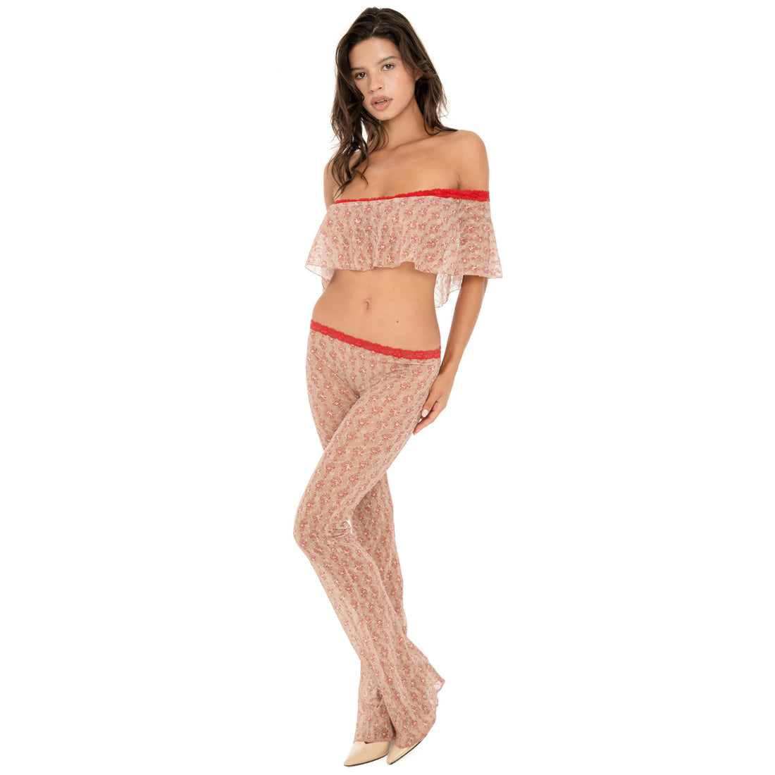 Front three-quarter view of the Liani Pant in Cherry Blossom, showing the sheer floral lace, low-rise fit, red lace waistband and flared leg. **cherry blossom