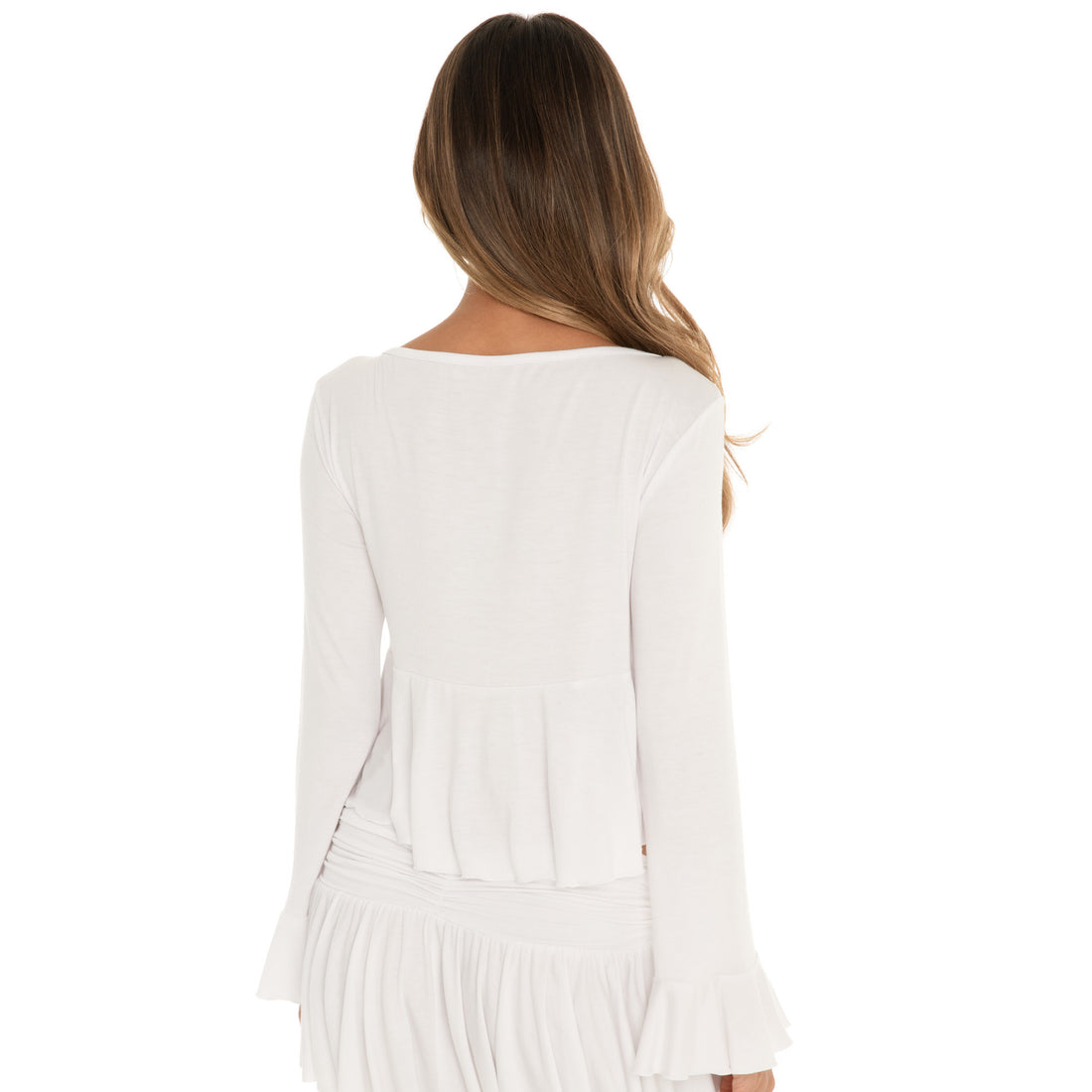 Back view of Lunet top in white with long sleeves and flowy ruffle hem detail **white