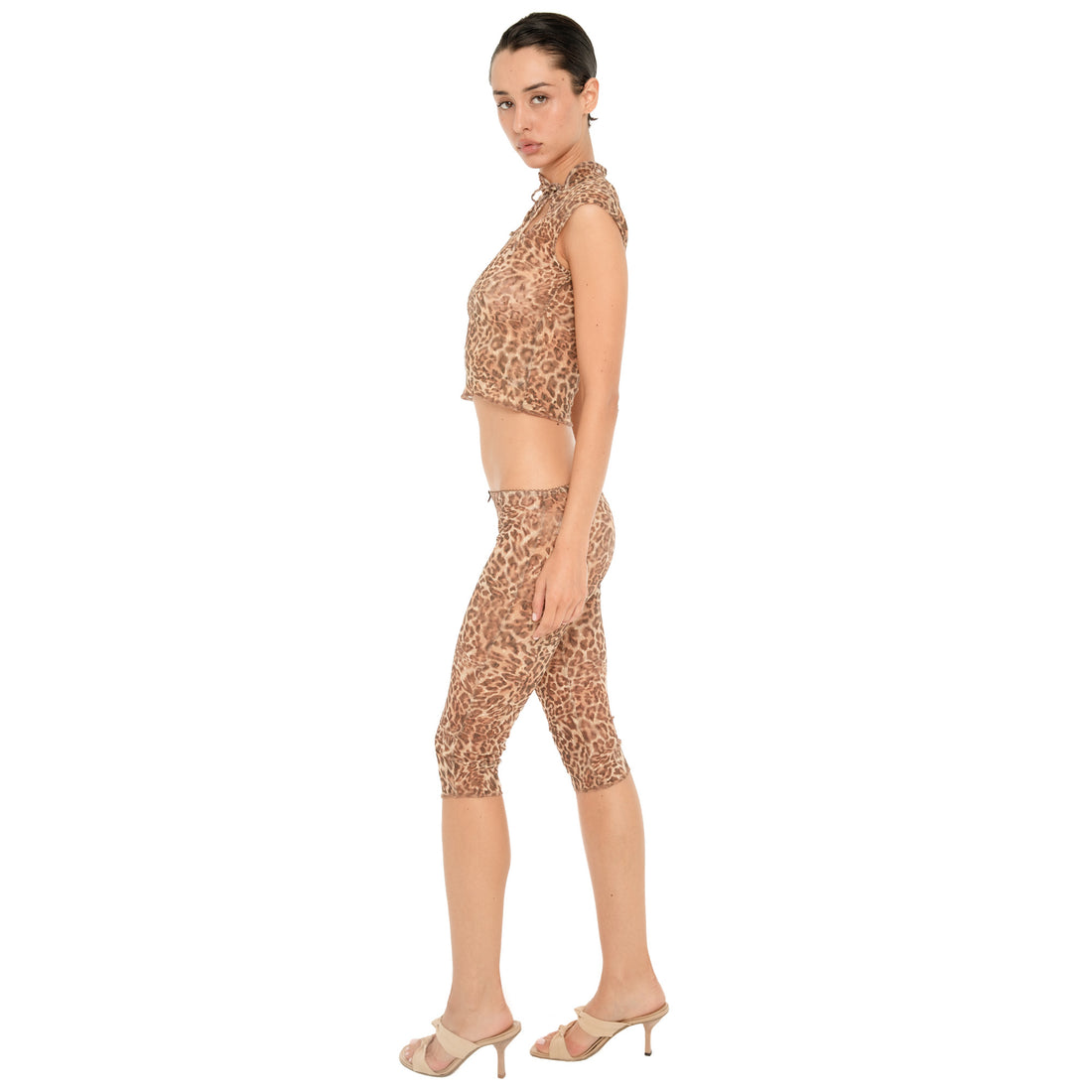 Side view of model wearing the Lyli Capri in sheer brown leopard print, showing the low rise waist, fitted silhouette, and below the knee length