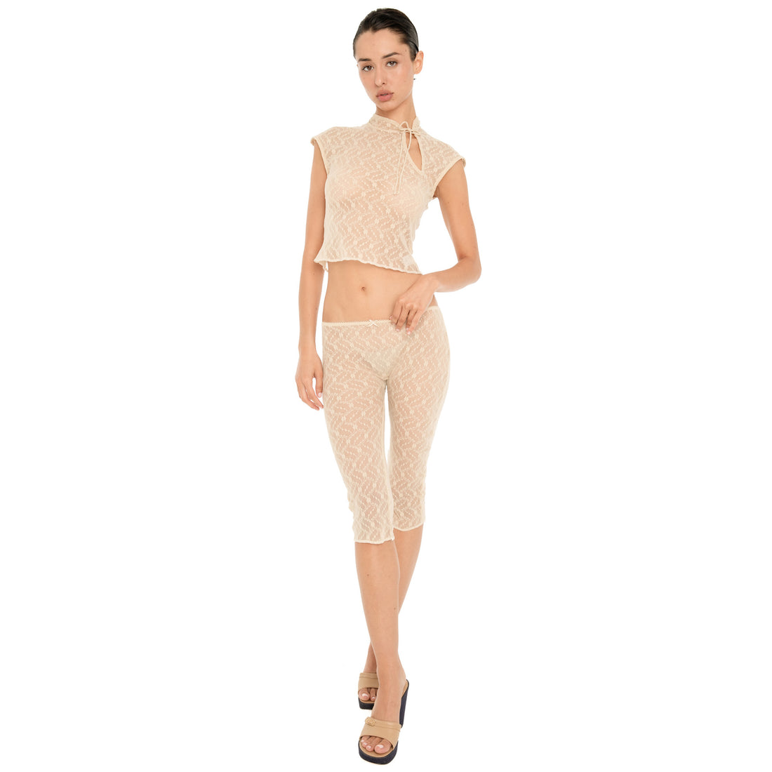 Model wearing the Lyli Capri in nude sheer floral lace with a matching cropped lace top, shown full length against a white background. **nude