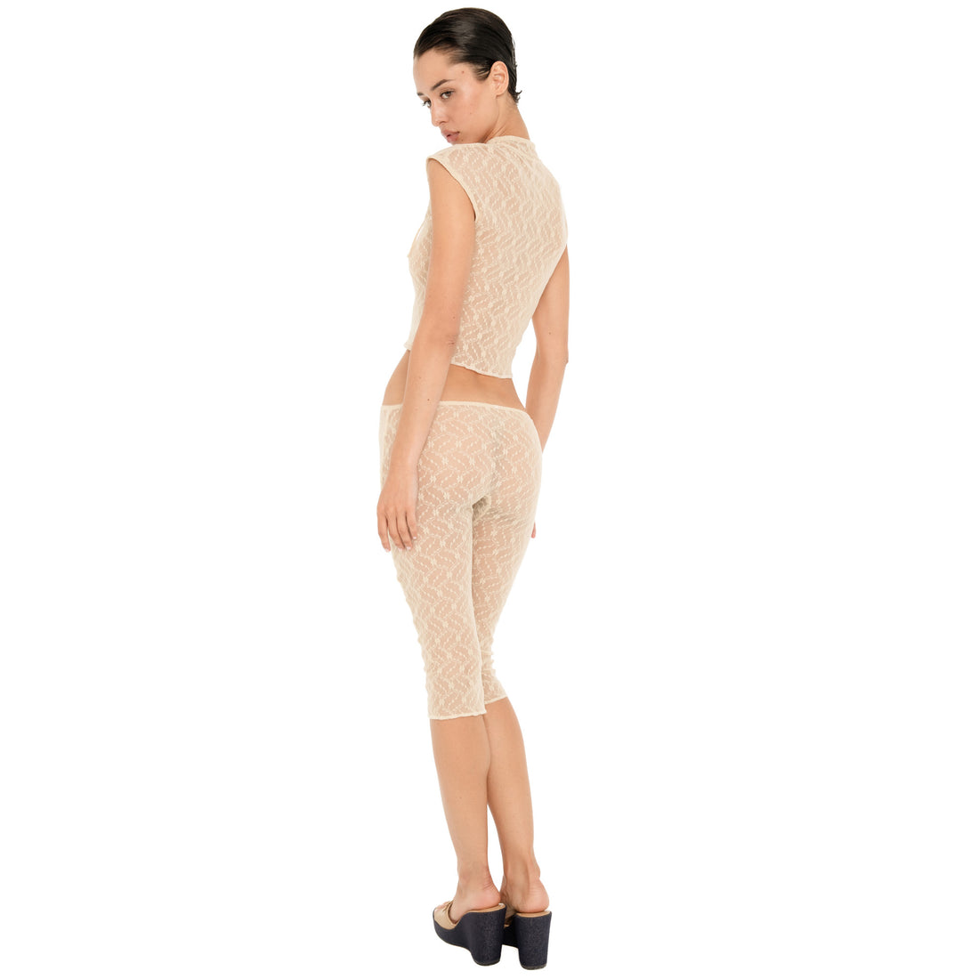 Model shown from the back wearing the nude sheer floral lace Lyli Capri with a matching cropped lace top, showing the fit and lace pattern from behind. **nude
