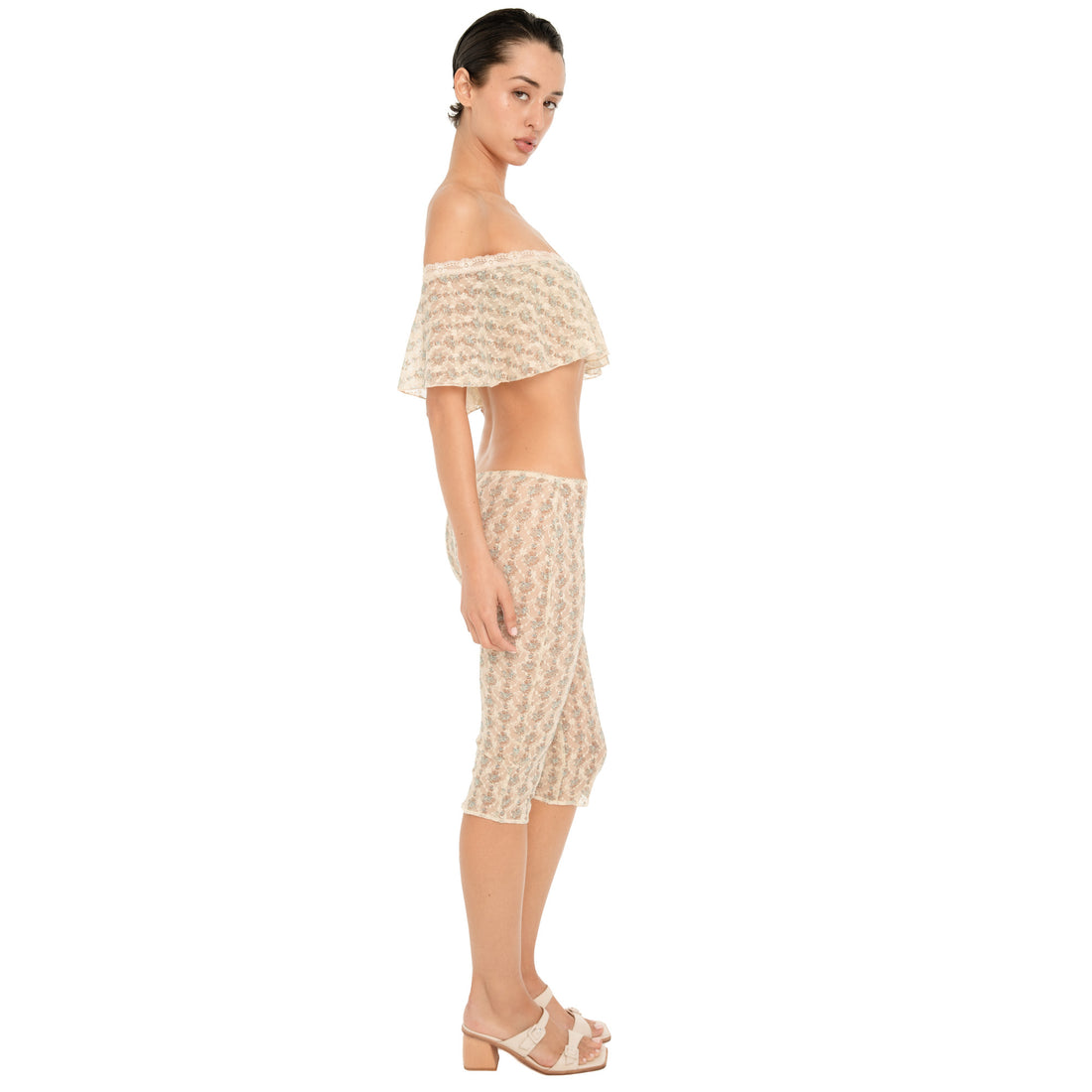 Side view of the cream sheer floral lace Lyli Capri, showing the low rise fit and fitted knee length silhouette, styled with the matching off shoulder top. **sky blossom