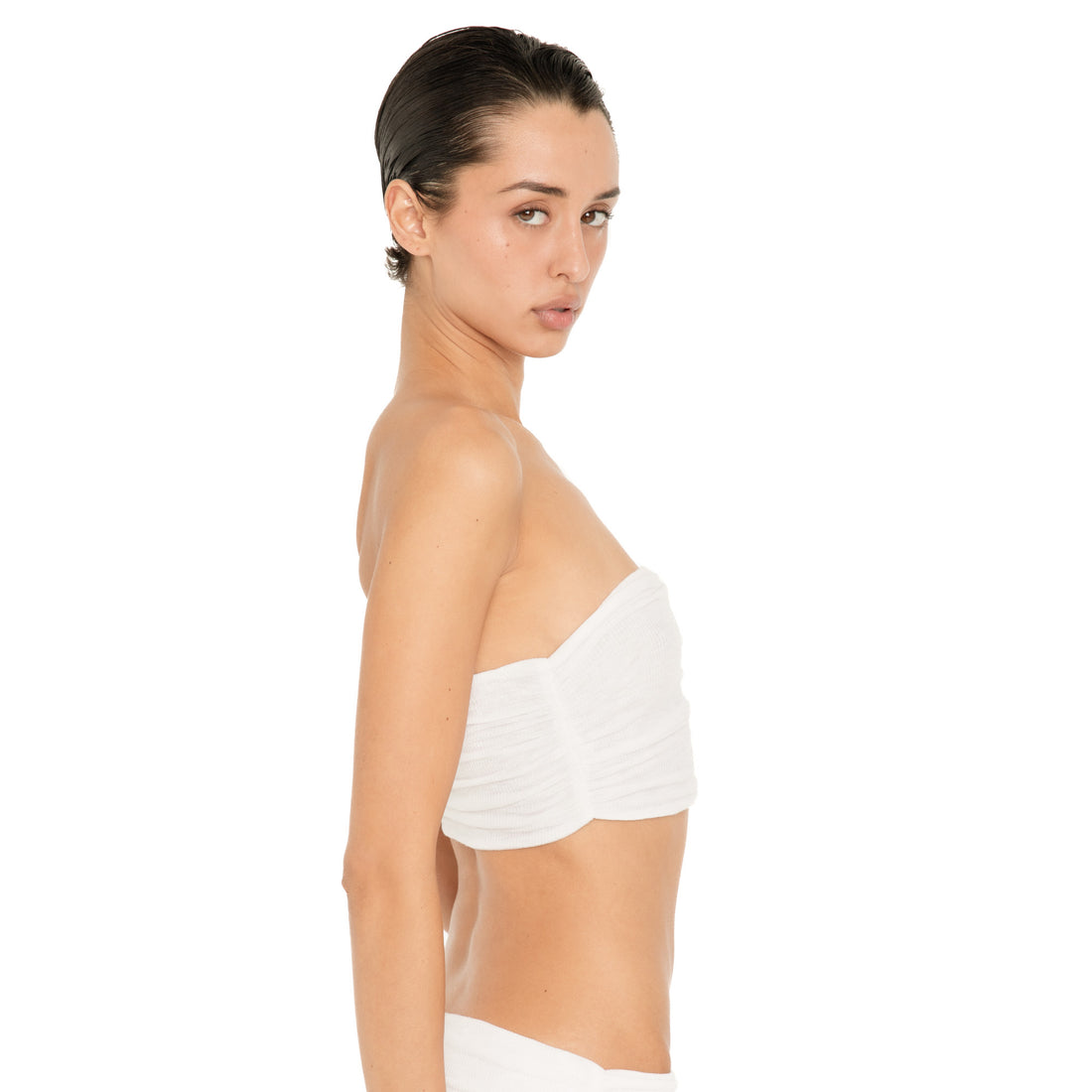 Close side view of model wearing the Meili Bandeau in White, highlighting the strapless neckline, gathered fabric and cropped fit. white