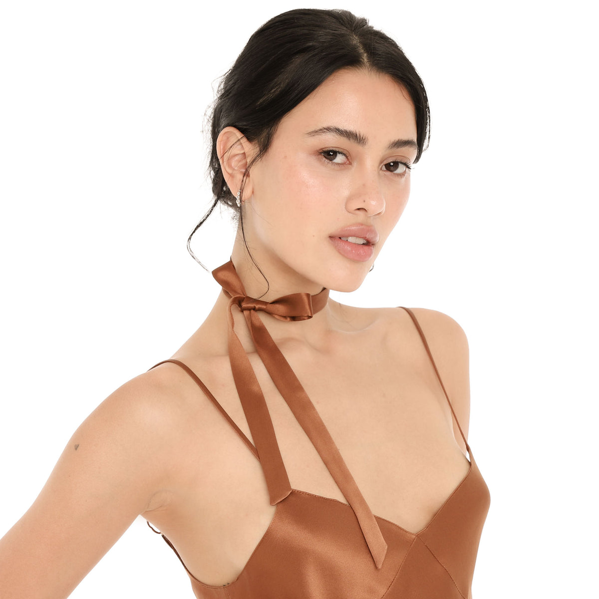 Close-up of the copper silk Nida Choker tied in a small bow at the side of the neck, with long ribbon tails draping over the collarbone **copper