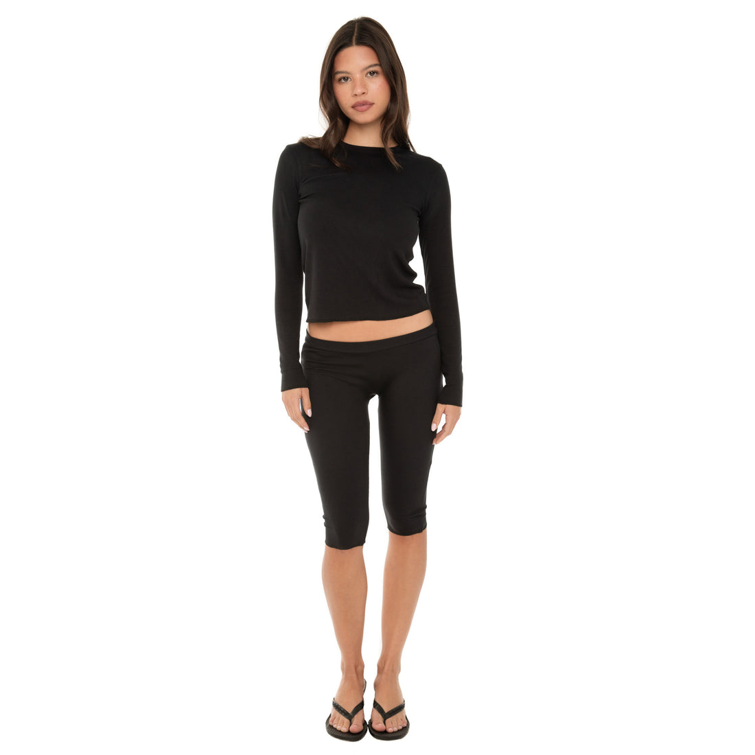 Model wearing the NIIMA Top in black, a long-sleeve fitted modal top with exposed overlock hem.**black