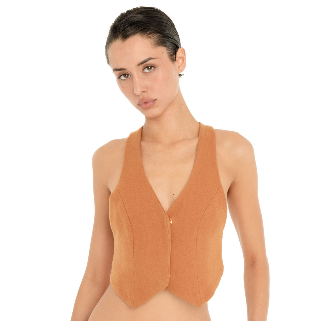 Close-up front view of the Pau Vest in Saffron, highlighting the deep V neckline, curved seam detailing, fitted silhouette and small gold-tone front closure. **saffron