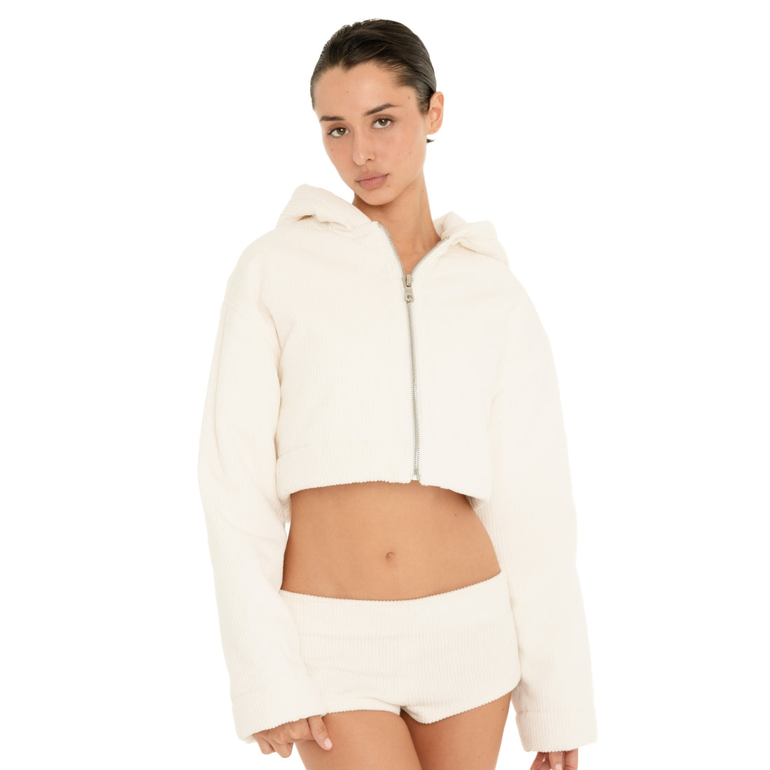 Front view of model wearing the ivory Sfera Jacket partially unzipped, showing the cropped fit, oversized hood and silver zipper. **ivory