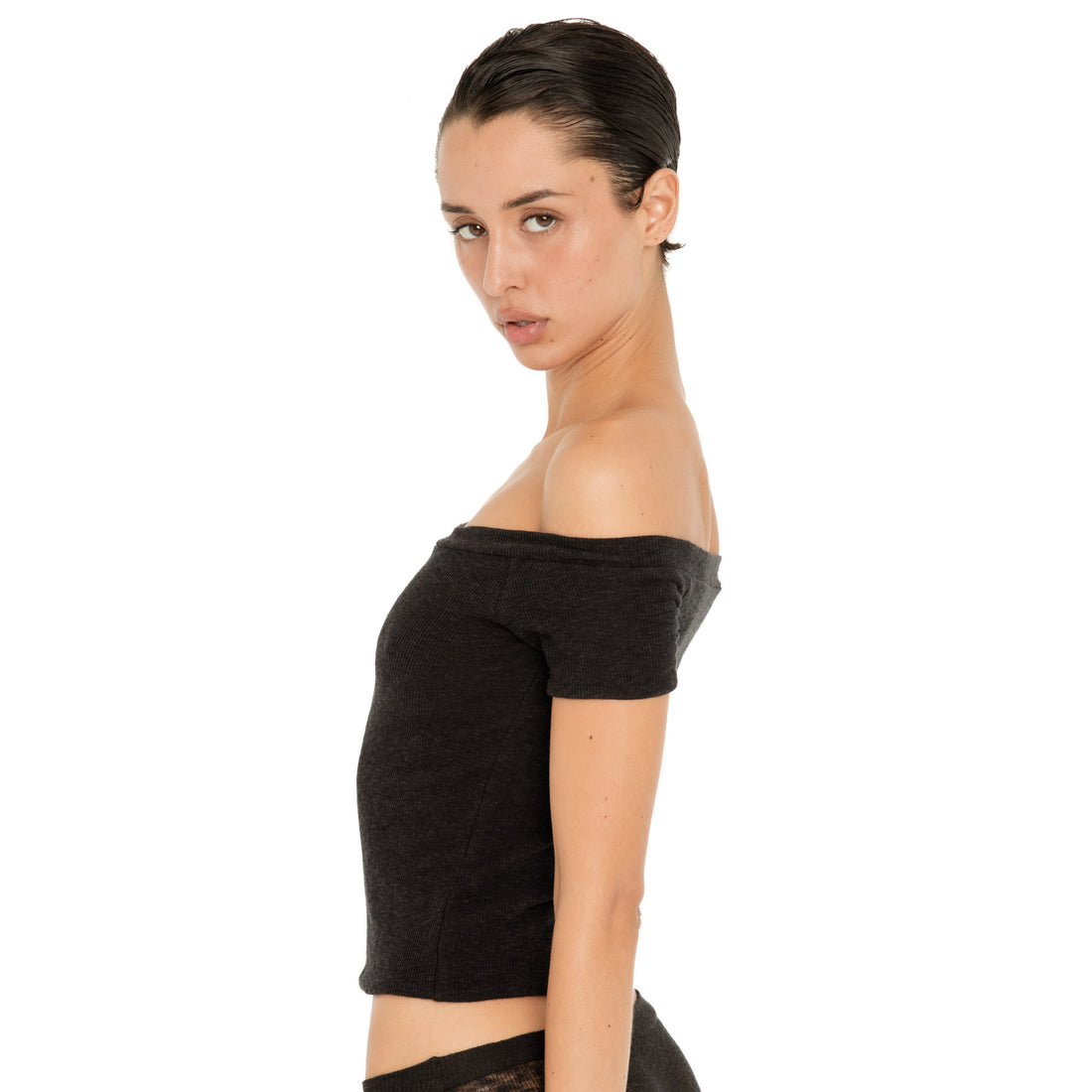 Side view of the black Solei top, showing its fitted silhouette, short sleeves, and wide off-the-shoulder neckline **black