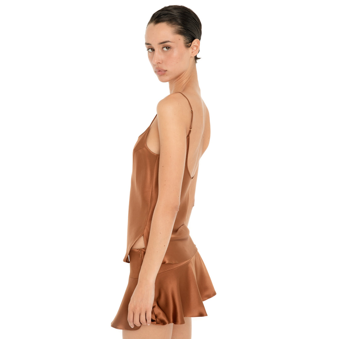 Side view of the Are You Am I Syra Skirt in Copper, showing the lustrous silk charmeuse, low-rise fit and softly flared silhouette. **copper