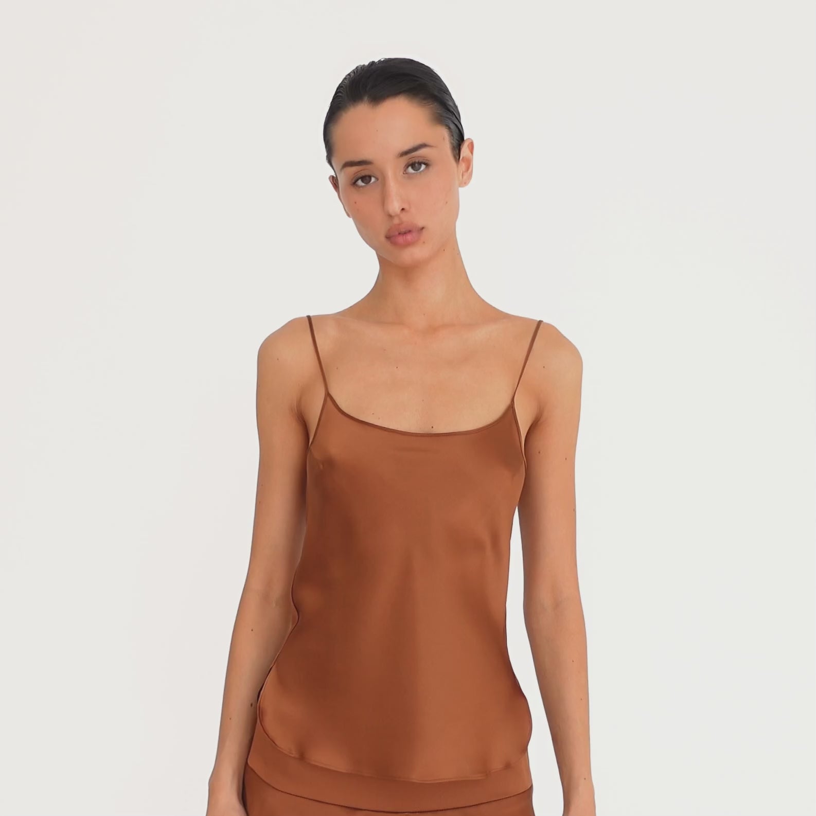 Video: Model wearing the Are You Am I Syra Camisole in Copper with the matching Syra Skirt, showing the silk camisole from multiple angles. **copper