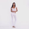 Model wearing and moving in the Illi Pant in White, a low-rise fitted pant with a wide fold-over waistband and subtly flared leg. **white