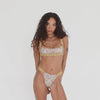 Model wearing Are You Am I Nailah Swim Bottom in Paisley – high-cut bikini with ruched contrast trim, shown in motion with matching Nailah Swim Top. **paisley