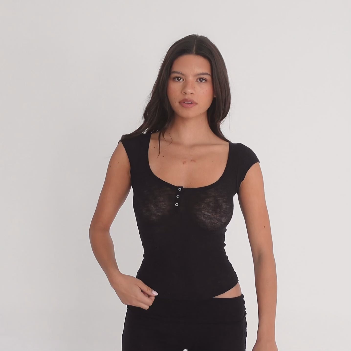 Model wearing a black short sleeve scoop neck henley top with three-button placket and fitted silhouette, shown from front, side, and back views to highlight the semi-sheer fabric and fit. **black