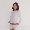 Model wearing white Caeli long sleeve thermal top, showing fit, fabric drape, and cropped length in motion **white