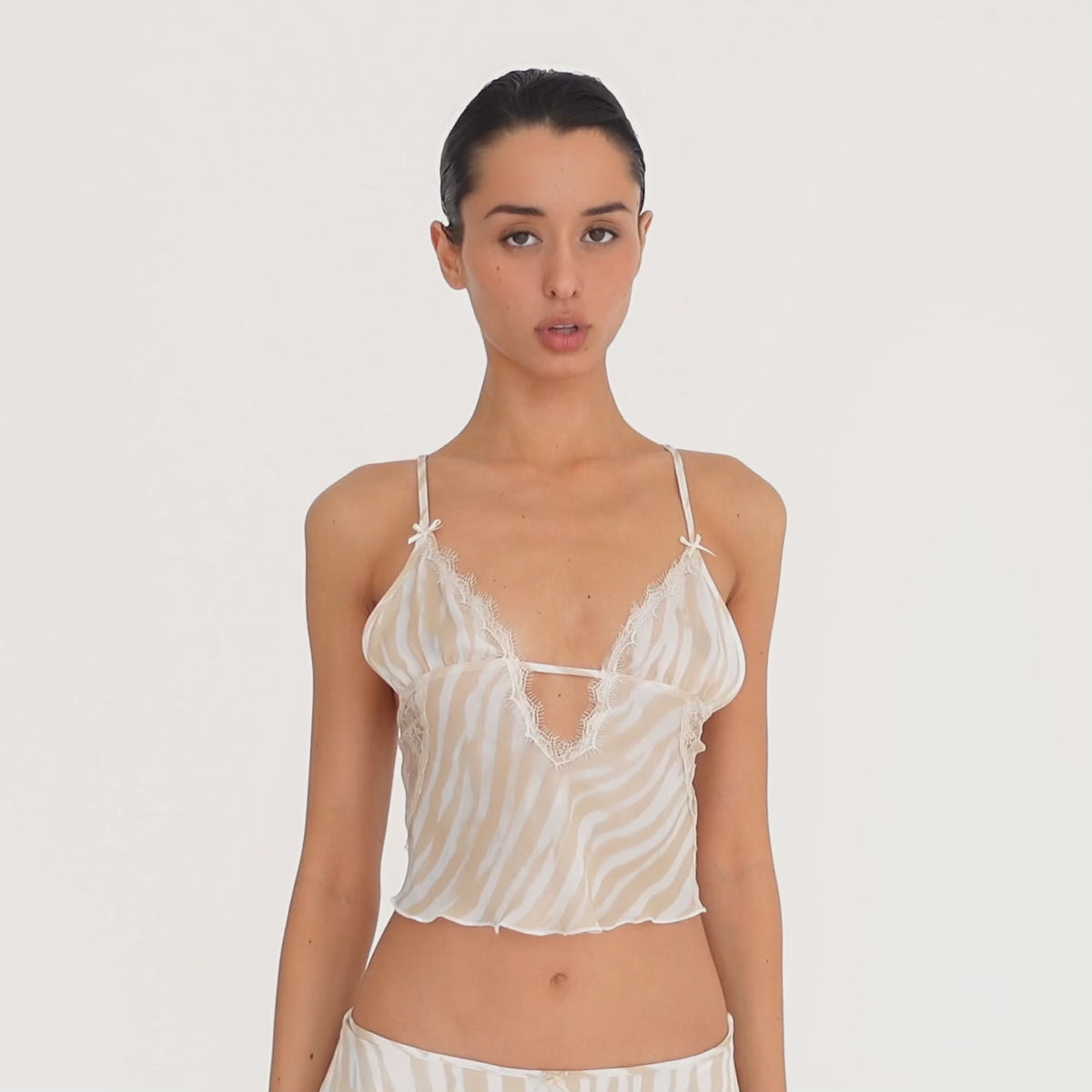Video: Model wearing and moving in the Are You Am I Aria Camisole in Ivory Latte, showing the sheer zebra print, lace detailing, open tie back and matching Aria Skirt. **ivory-latte