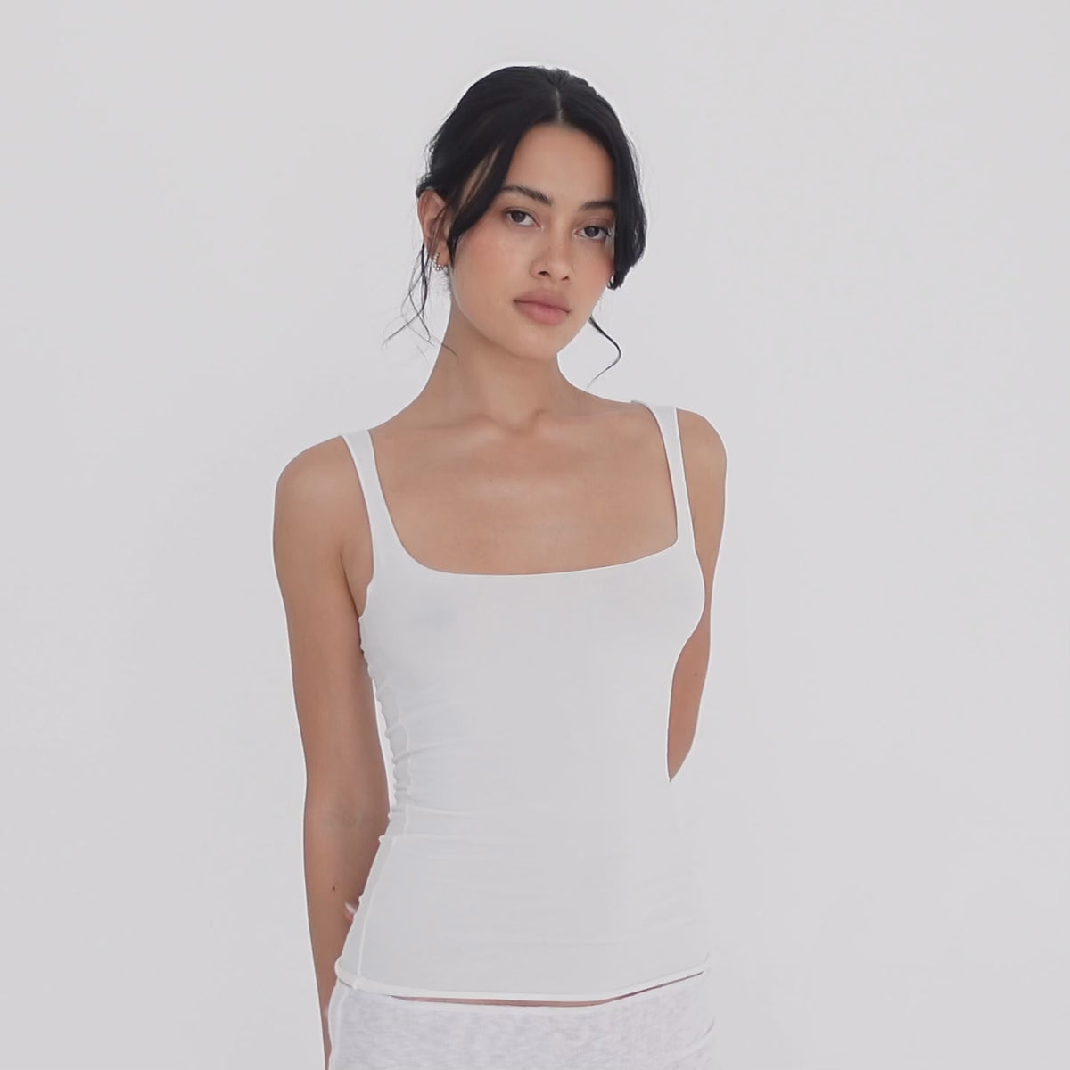 Model turning slowly in the white Elix Tank, showing the square neckline from the front, the fitted side profile and the low scoop back **white