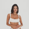 Video of model wearing the Nailah Swim Top in Cream, showing the fit, texture, and gathered detailing from multiple angles **cream