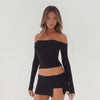 Video of model wearing the Anouck Top in black styled with a black low rise skort, showing movement, fit, and stretch of the fabric **black