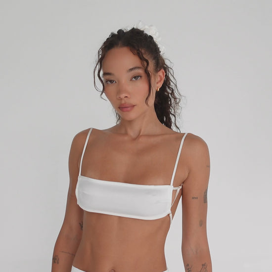 Model showcases Are You Am I Missi Bra in white silk charmeuse. Features micro fit, signature strap configuration, and open back with adjustable straps. **white