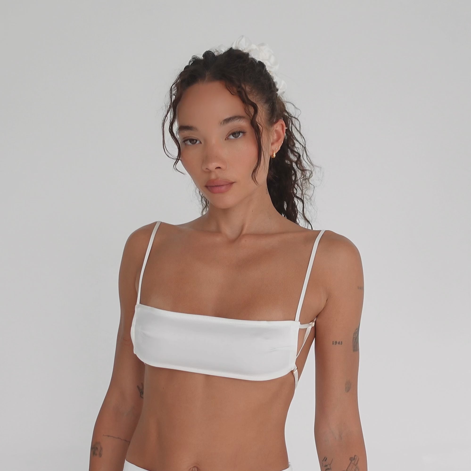 Model showcases Are You Am I Missi Bra in white silk charmeuse. Features micro fit, signature strap configuration, and open back with adjustable straps. **white