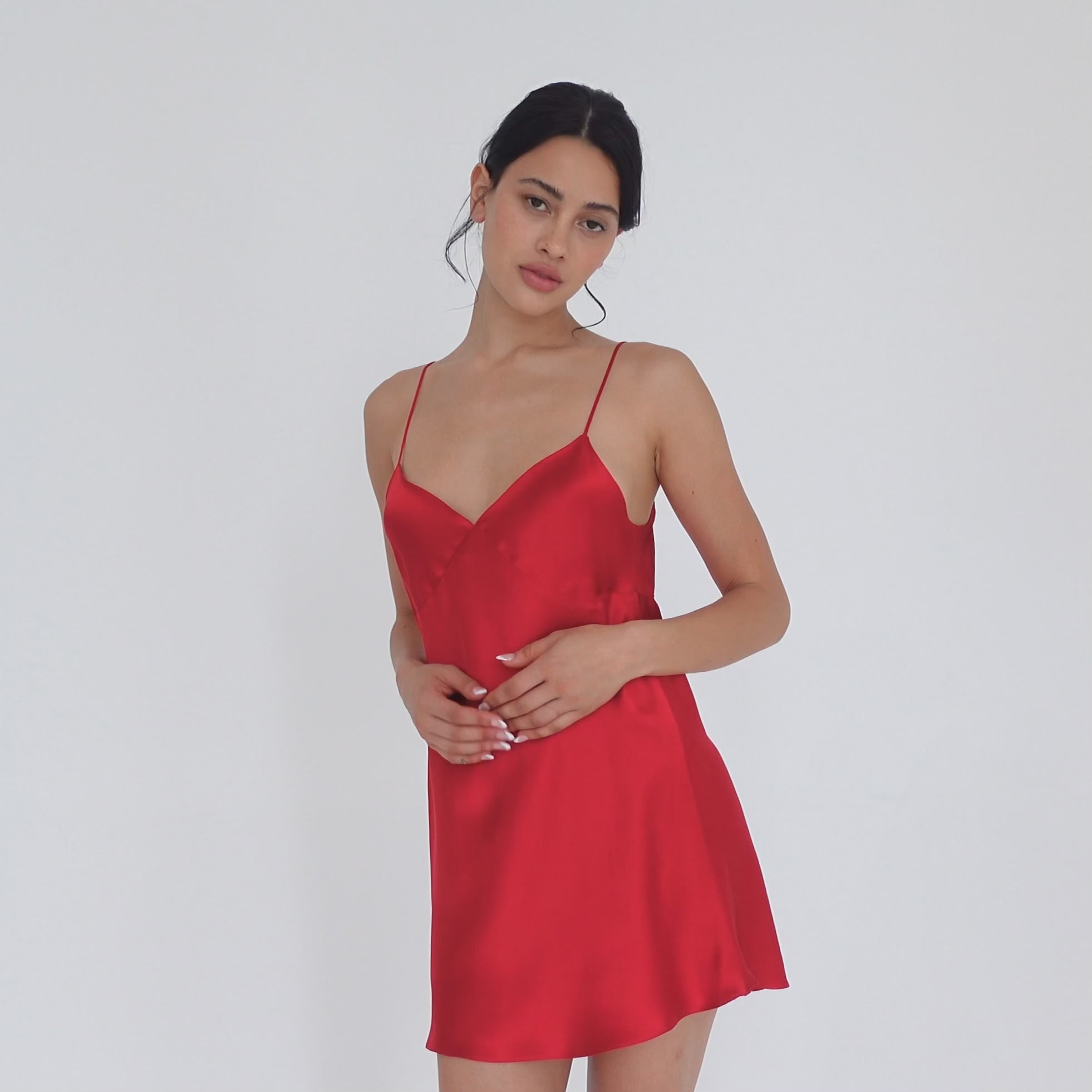 Model turning slowly in the cherry red silk Eisling Dress, showing the V neckline from the front, the A-line side profile and the low scoop back. **cherry red