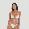 Video: Model wearing and moving in the ARE YOU AM I Iti Swim Bottom in cream, featuring a minimal silhouette, double side straps, and cheeky coverage **cream