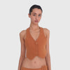 Video: Model turns while wearing the ARE YOU AM I Pau Vest in Saffron, showing its fitted cropped silhouette, deep V neckline, pointed front hem and open racerback shape from multiple angles. **saffron