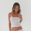 Video of model wearing white ribbed Illi tank and matching capris, moving naturally to show fit, stretch, and fabric drape **white