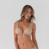 Video of a model wearing the Llai Swim Top in latte with matching swim bottoms. The model slowly turns to reveal the front, side and back views of the bikini. The video showcases the triangle cups, ruffle shoulder straps, adjustable ties and tie-back closure, allowing viewers to see the shape, fit and drape of the swim top from every angle. **latte