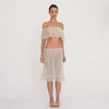 Video: Model wearing the Liulu skirt in nude, showing the sheer floral lace, low rise fit, lace trimmed waistband, midi length, and ruffled hem from multiple angles. **nude