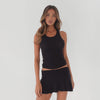 Model standing and slowly shifting poses in a black ribbed mini skirt and tank set, demonstrating the skirt’s flow, stretch, and movement from multiple angles **black