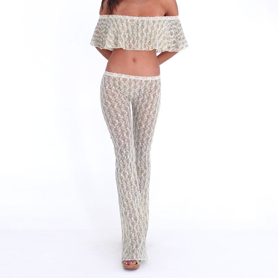 Model wearing and moving in the Liani Pant in Sky Blossom, showing the sheer floral lace, low-rise fit and fluid flared leg **sky blossom