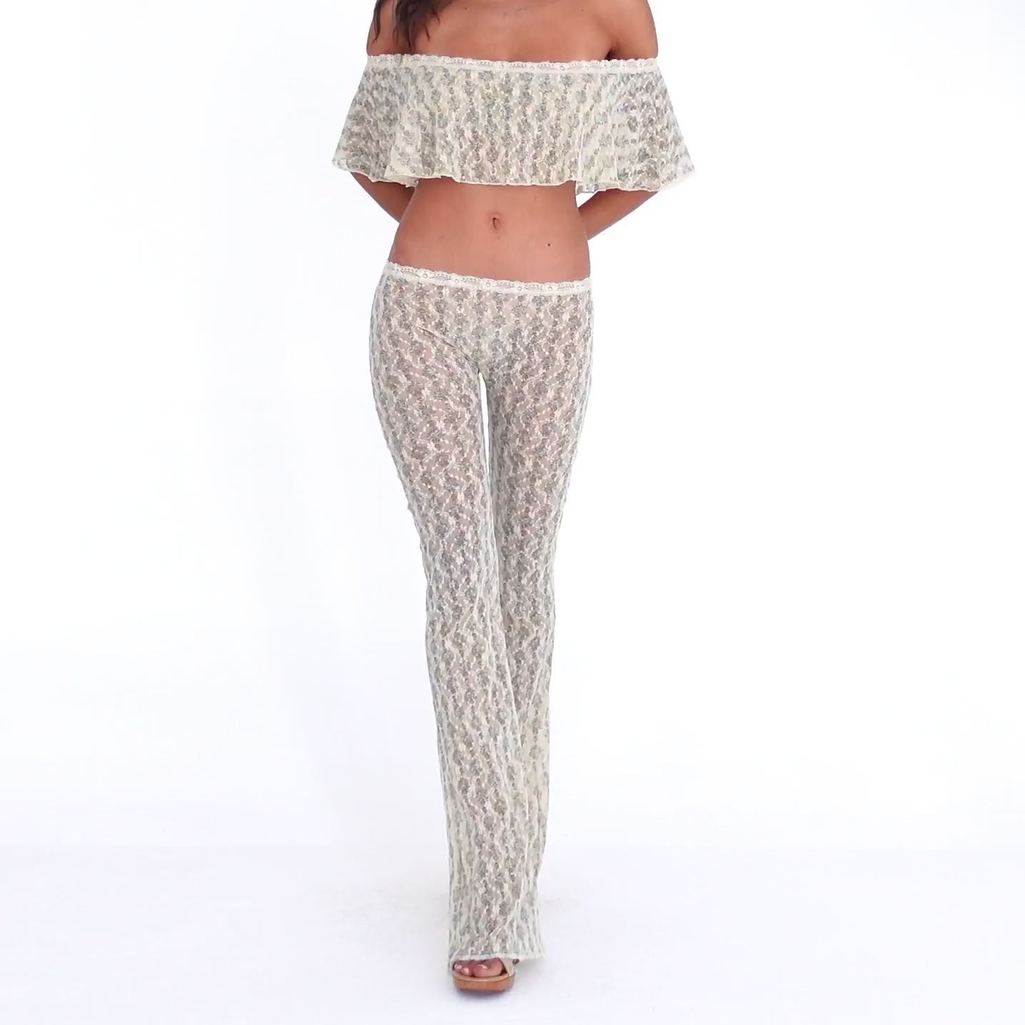 Model wearing and moving in the Liani Pant in Sky Blossom, showing the sheer floral lace, low-rise fit and fluid flared leg **sky blossom
