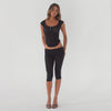 Video showing a model wearing a fitted cap sleeve henley top and capri leggings, highlighting the stretch, sheerness, and movement of the lightweight baby rib fabric in motion **black