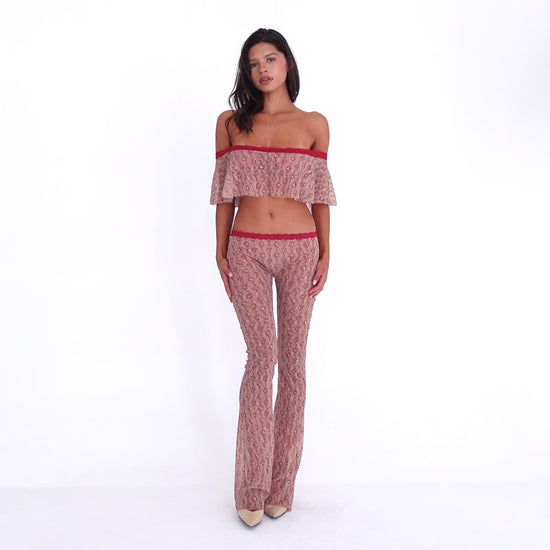Model wearing and moving in the Liani Pant in Cherry Blossom, showing the sheer floral lace, low-rise fit and fluid flared leg **cherry blossom