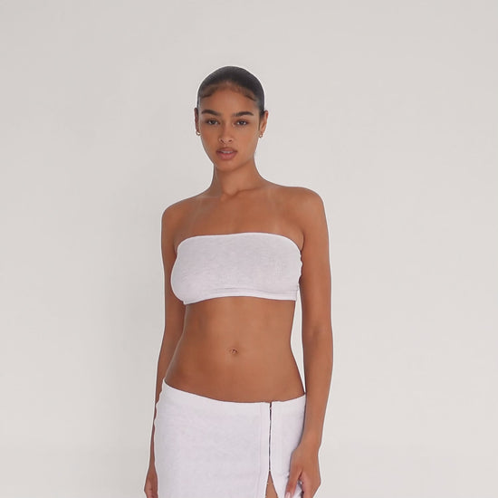 Video: Model wearing the Aili Tube in white, showing the fitted strapless silhouette and lightweight ribbed knit in motion **white