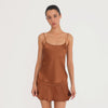 Video: Model wearing and moving in the Are You Am I Syra Skirt in Copper, showing the fluid drape and movement of the silk charmeuse mini skirt. **copper