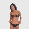 Video: Model wearing the black ARE YOU AM I Iselle Bottom with the matching lace bra, moving and turning to show the sheer floral lace design and low-rise fit **black