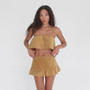 Video of model walking and turning in the Etra Top and Skirt in butterscotch suede, demonstrating the fluidity of the layered top and movement of the ruffled hemline **butterscotch