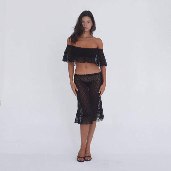 Model wearing and moving in the black Liulu Skirt with matching lace top, showing the skirt’s sheer floral lace, low-rise fit and ruffled midi hem **black