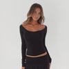 model moving and turning in a fitted off shoulder long sleeve top with a scoop neckline, showing the silhouette and stretch of the fabric **black