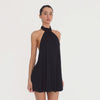 Video: Model wearing the black Stara Dress, showing the high halter neckline, loose draped silhouette, low cut sides, open back, long neck ties, and flared mini hem from multiple angles. **black