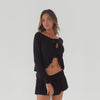 Model wearing Lunet top and skirt set in black in motion showing fit, drape, and movement of ruffle hem and sleeves **black