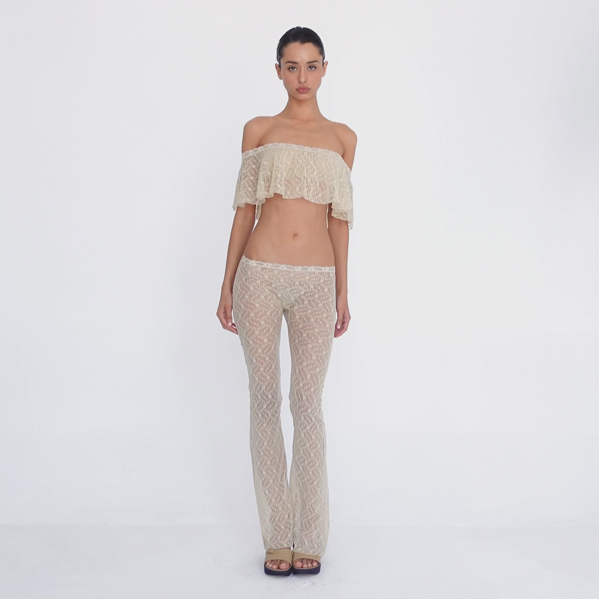 Video: Model turns and poses in the Liani Pant in Nude, showing the sheer floral lace, low rise waistband and flared silhouette from multiple angles. **nude